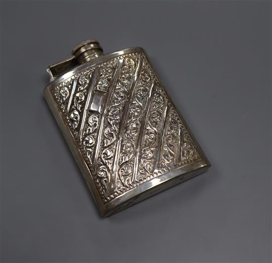 An embossed white metal hip flask inscribed sterling silver,